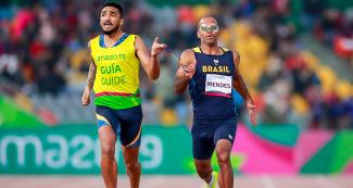 Daniel Mendes from Brazil running with his guide Wendel Da Souza during the men’s 400 m T11 event at the National Sports Village – VIDENA, Lima 2019