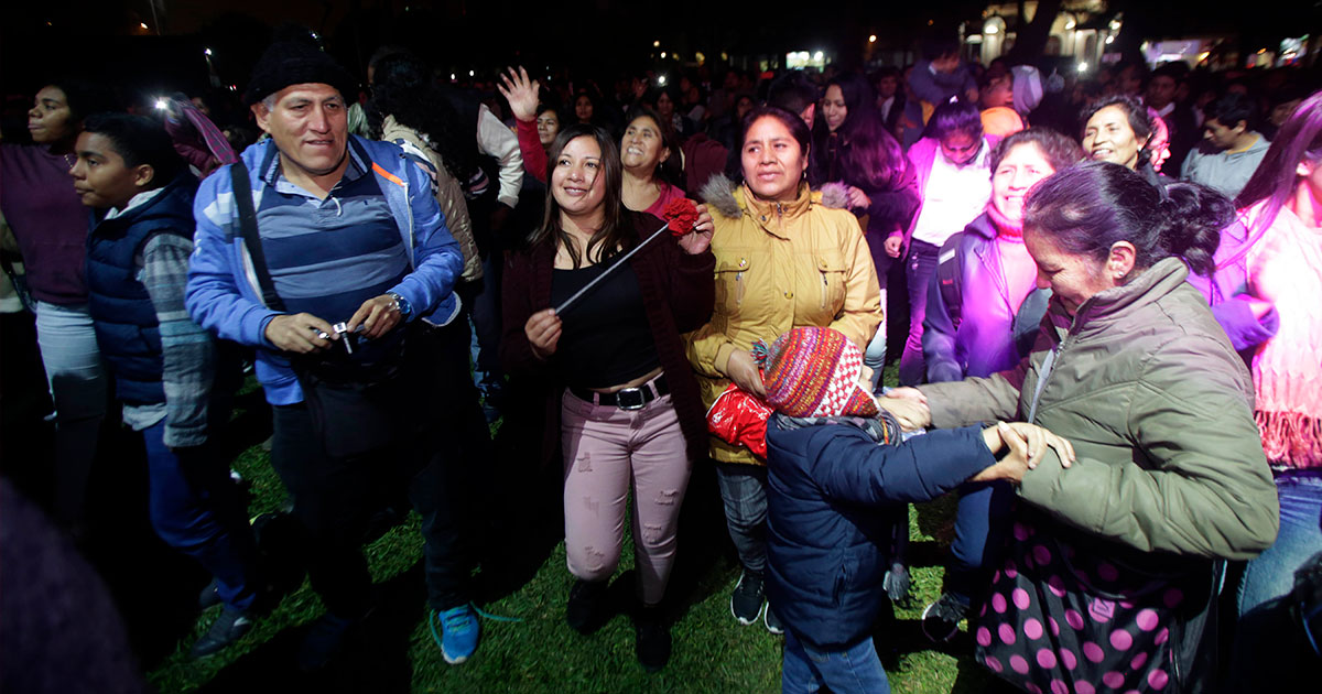 Grupo de peruanos de diversas edades bailando y celebrando