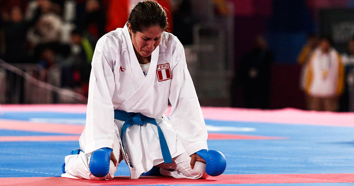Alexandra Grande, Peruvian karateka, squats to celebrates the gold medal at Lima 2019.