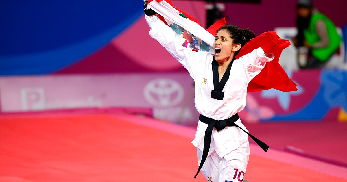 La Para deportista peruana Angélica Espinoza celebra con una bandera sobre la espalda la medalla de oro de Para taekwondo en Lima 2019