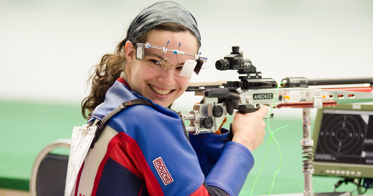 Mckenna Dahl sonríe mirando hacia atrás mientras sostiene su escopeta en los Juegos Parapananses Lima 2019.