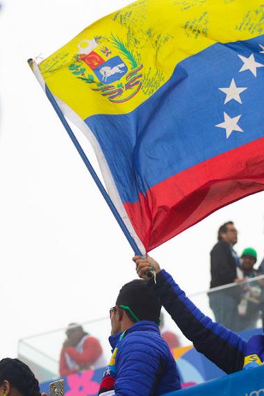 Fanática Venezolana flameando la bandera de su país en competencia de Surf 