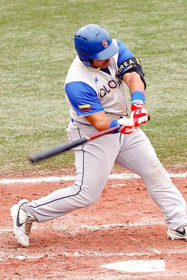Colombian baseball player hits the ball hard during the men’s preliminary round against Canada at the Villa María del Triunfo Sports Center 
