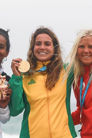 Maria Fernandez de Perú (plata), Chloe Calmon de Brasil (oro) y Mathea Dempfle de Canadá (bronce) celebran sus medallas en surf, ¬en Juegos Lima 2019 en Punta Rocas.