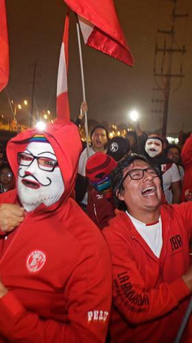 Grupo de peruanos sosteniendo banderas y tocando tambores a manera de celebración