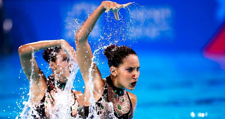 : Laura De Souza and Luisa Nuñez Porto raise their arms in an artistic pirouette at the Lima 2019 Pan American Games
