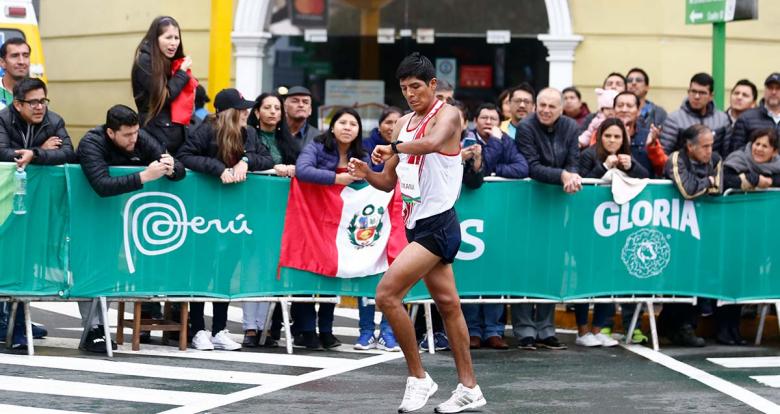 Peruvian athlete, José Carlos Mamani Flores, checks his watch to calculate his time during the Lima 2019 race walk competition at Parque Kennedy in Miraflores. 