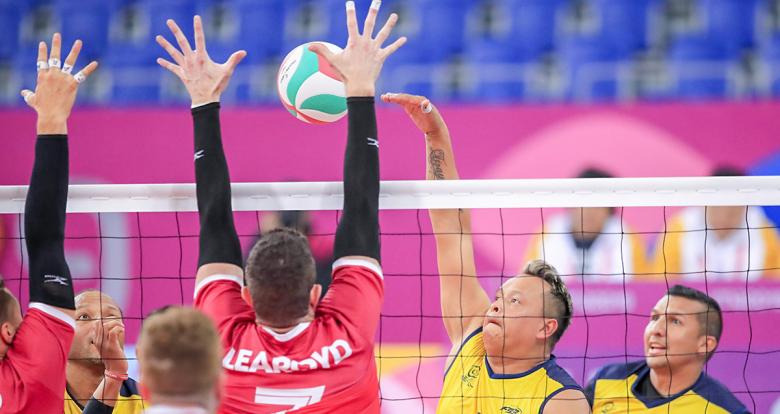 Colombian Carlos Valencia returns the ball to Canadian Douglas Learoyd in Lima 2019 sitting volleyball match held at the Callao Regional Sports Village
