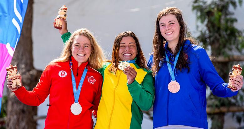 Michaela Corcoran from the US (bronze), Lois Betteridge from Canada (silver) and Ana Satila from Brazil (gold) show their medals and Milco statuettes in Río Cañete - Lunahuana