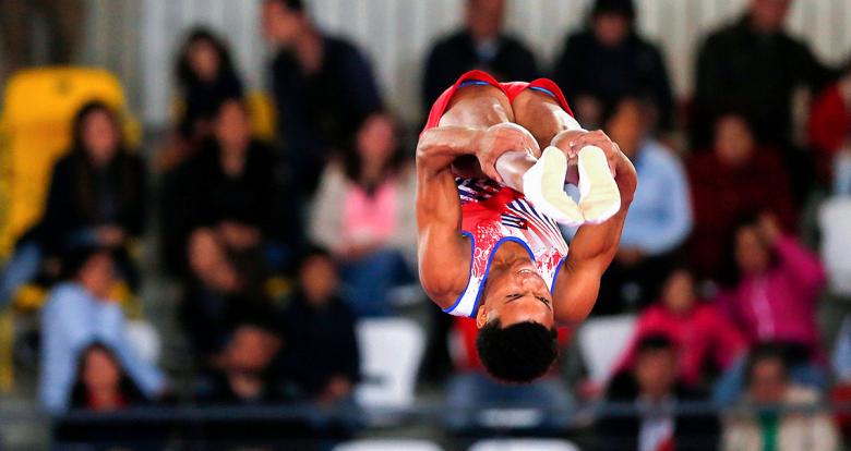 Cuba’s Alexander Rodríguez jumps with legs extended in the trampoline competition at the Lima 2019 Games held at the Villa El Salvador Sports Center