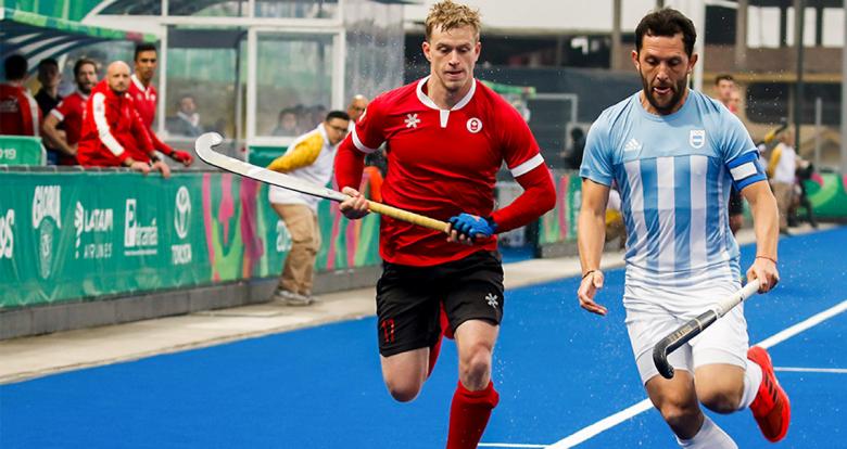 David Bisset de Canadá disputa el balón con Pedro Ibarra de Argentina durante partido de hockey, en los Juegos Panamericanos Lima 2019, en el Complejo Deportivo Villla Maria del Triunfo