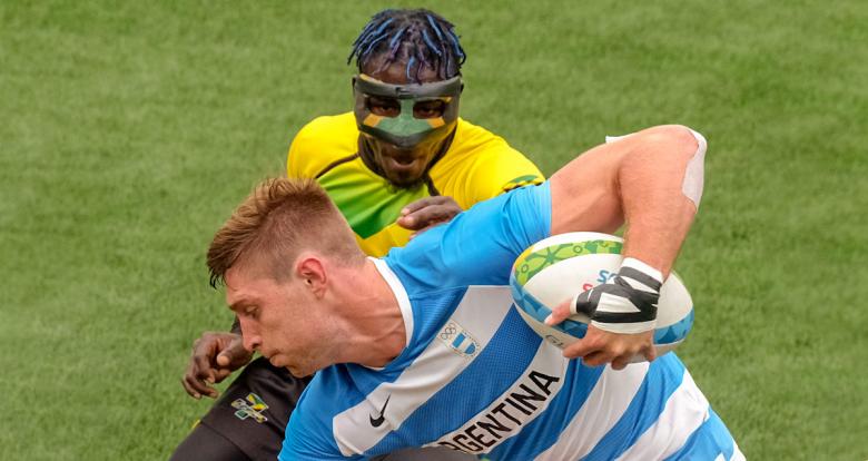 Matias Osadczuk de Argentina sostiene el balón de rugby mientras el jamaiquino Orlando Edie lo persigue para arrebatársela