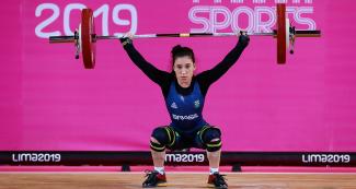 Natasha Figueiredo lifts weights during her performance