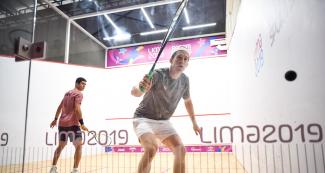 Diego Elías, con su raqueta en alto, juega squash para alcanzar el triunfo frente a USA 
