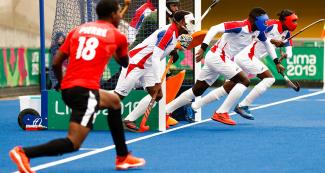 Cuban hockey players defend a short corner against Trinidad and Tobago at Lima 2019.