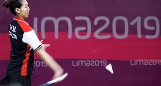 Michelle Li se prepara para golpear la pluma con su raqueta de bádminton en Lima 2019