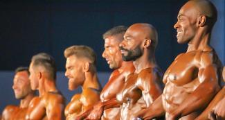 Bodybuilders perform a pose during a bodybuilding competition.