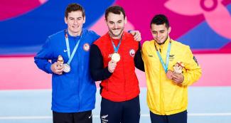 American Robert Neff (silver), Chilean Tomas Gonzalez (gold), and Colombian Andres Martinez (bronze) in the men’s artistic gymnastics podium at the Villa El Salvador Sports Center