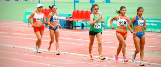 A group of female athletes competing against each other in a race walking event. 
