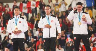 Jhon Trebejo, Oliver del Castillo y Carlos Lam, del equipo peruano de karate kata por equipos, posan orgullosos con sus medallas de oro de los Juegos Lima 2019 en el Polideportivo Villa el Salvador