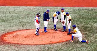 Colombian baseball team groups together in the match for the bronze medal at the Villa María del Triunfo Sports Center during Lima 2019 Games