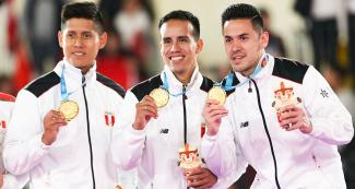 Jhon Trebejo, Oliver del Castillo y Carlos Lam, del equipo peruano de karate kata por equipos, celebran haber obtenido el oro luego de vencer a México en los Juegos Lima 2019 en el Polideportivo Villa el Salvador