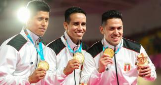 El equipo peruano de karate kata, conformado por Jhon Trebejo, Oliver del Castillo y Carlos Lam, posa con sus medallas de oro y amplias sonrisas en los Juegos Lima 2019 en el Polideportivo Villa el Salvador