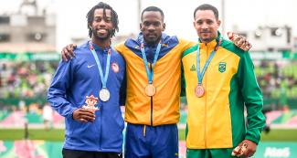 Atletas Fredie II Crittenden, Shane Brathwaite, Eduardo Dos Santos, ganadores de competencia de 110 metros de obstáculos se abrazan al ganar, en los Panamericanos Lima 2019. 