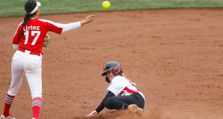Jennifer Gilbert from Canada in a cloud of dust competing against Anissa Urtez from Mexico in the Lima 2019 women’s softball preliminary round held at the Villa María del Triunfo Sports Center