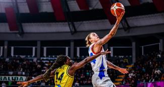 La puertorriqueña Jazmone Gwathmey a punto de encestar, mientras que Martyn Vente de Colombia intenta impedírselo en partido de baloncesto, en los Juegos Panamericanos Lima 2019, en el Coliseo Eduardo Dibos