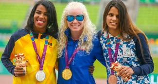 Rayane Soares Da Silva de Brasil (plata), Kimberly Crosby de EE. UU. (oro) y Bianca Candela Cerrudo de Argentina (bronce) posan orgullosas con sus medallas de Para atletismo 100 m T13 en la Villa Deportiva Nacional – VIDENA en Lima 2019