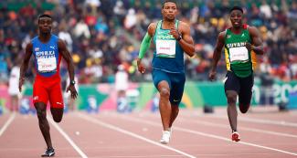 Mayovanex de Oleo de República Dominicana, Rodrigo Pereira de Brasil y Emanuel Archibald de Guyana, se enfrentan durante carrera masculina de 100 metros en la semifinal de atletismo, en los Juegos Lima 2019