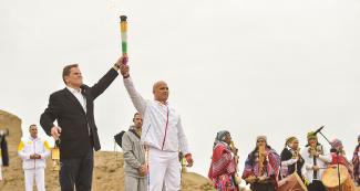 Carlos Felipa, Peruvian Para athlete, and Carlos Neuhaus, president of the Lima 2019 Pan American Games Organizing Committee hold the torch together at the Lima 2019 Parapan American Torch ceremony held in Pachacamac.