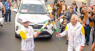 Senior citizen torchbearer receives the Lima 2019 Parapan American torch