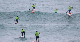 Surfers do their best in the sea to obtain the gold medal in the women’s SUP surfing final in Punta Rocas.