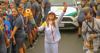 La embajadora de Lima 2019 Sofía Mulánovich sonríe y saluda a la cámara con la antorcha en la mano en el tercer día del Relevo de la Antorcha Parapanamericana de Lima 2019