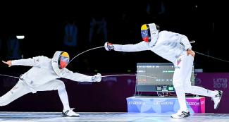 Venezuelan fencers fight in a duel during the men’s individual épée final at the Lima Convention Center
