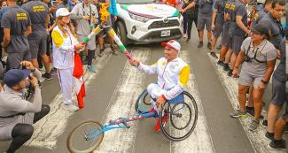 The Lima 2019 Ambassador Sofía Mulánovich lights the torch of the next relay on the third day of the Lima 2019 Parapan American Torch Relay