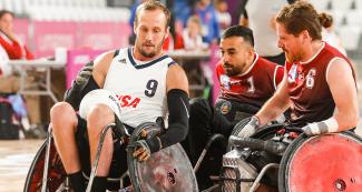  Eric Newby (USA) llevando el balón entre sus piernas mientras se enfrenta a dos jugadores chilenos durante partido de rugby en silla de ruedas en los Juegos Parapanamericanos Lima 2019. 