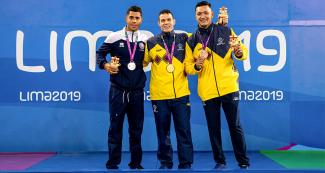 Darvin Baez de Puerto Rico (plata) y Daniel Giraldo (oro) y Diego Cuesta (bronce) de Colombia posan orgullosos en el podio de Para natación 100 m pecho masculino en Lima 2019 en la Villa Deportiva Nacional – VIDENA.