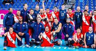 Equipos de Perú y EE. UU. de vóleibol sentados posan juntos para una foto luego de la victoria de EE. UU. en Lima 2019 en la Villa Deportiva Regional del Callao