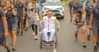 Un portador de la antorcha avanza sonriente en su silla de ruedas en el tercer día del Relevo de la Antorcha Parapanamericana de Lima 2019