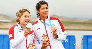 Mexican Karina Alanís and Beatriz Briones showing their bronze medals to the public at Albufera de Medio Mundo venue at Lima 2019 