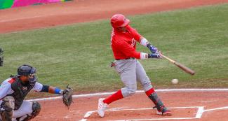 Dominican Miguel Gomez hits the ball against Cuba during Lima 2019 baseball game at Villa María del Triunfo Sports Center