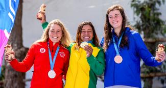 Michaela Corcoran de EE.UU. (bronce), Lois Betteridge de Canadá (plata) y Ana Satila de Brasil (oro) posan orgullosas con sus medallas y figuras de Milco, en los Juegos Lima 2019 en el Río Cañete en Lunahuana