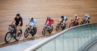 Las ciclistas femeninas Joanne Rodríguez, Lisandra Guerra, Marie Mitchell, Micaela Sarabia y Andrea Vera avanzan velozmente a lo largo de circuito cerrado, en los Juegos ima 2019 