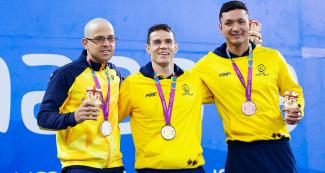 Brazilian Thomas Rocha, alongside Colombians Daniel Giraldo and Diego Cuesta, climb on to the podium to receive their medals for the Lima 2019 Parapan American Games Para swimming competition