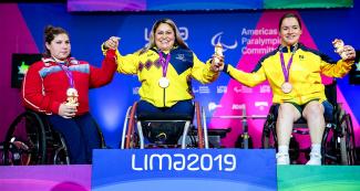 María Becker de Chile (plata), Bertha Fernández de Colombia (oro) y Amanda Sousa de Santos de Brasil (bronce) posan orgullosas en el podio de Para powerlifting mujeres -73 kg en Lima 2019 en la Villa Deportiva Nacional – VIDENA