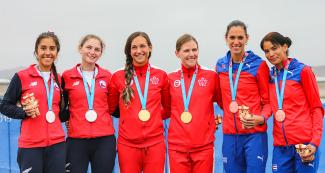 Equipos de Chile (plata), Canadá (oro) y Cuba (bronce) posan orgullosas con sus medallas luego de la competencia de doble par cortos peso ligero femenino en los Juegos Lima 2019 en la Albufera Medio Mundo - Huacho
