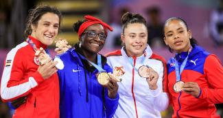 Canadian Olivia Di Bacco, American Tamyra Mensah, Mexican Ambar Garnica, and Cuban Yudari Sanchez posing with their medals after the freestyle wrestling final at the Lima 2019 Games.  
